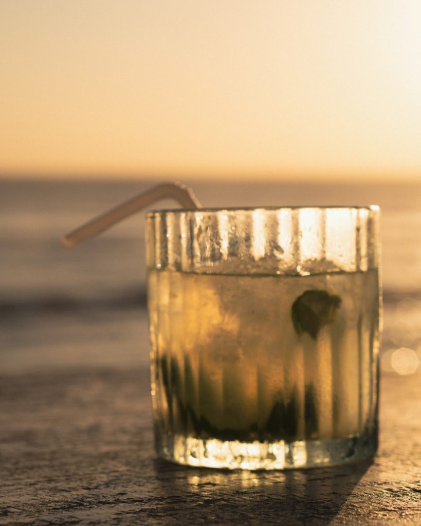 A cold drink on the beach glowing in golden sunset light on Nusa Lembongan
