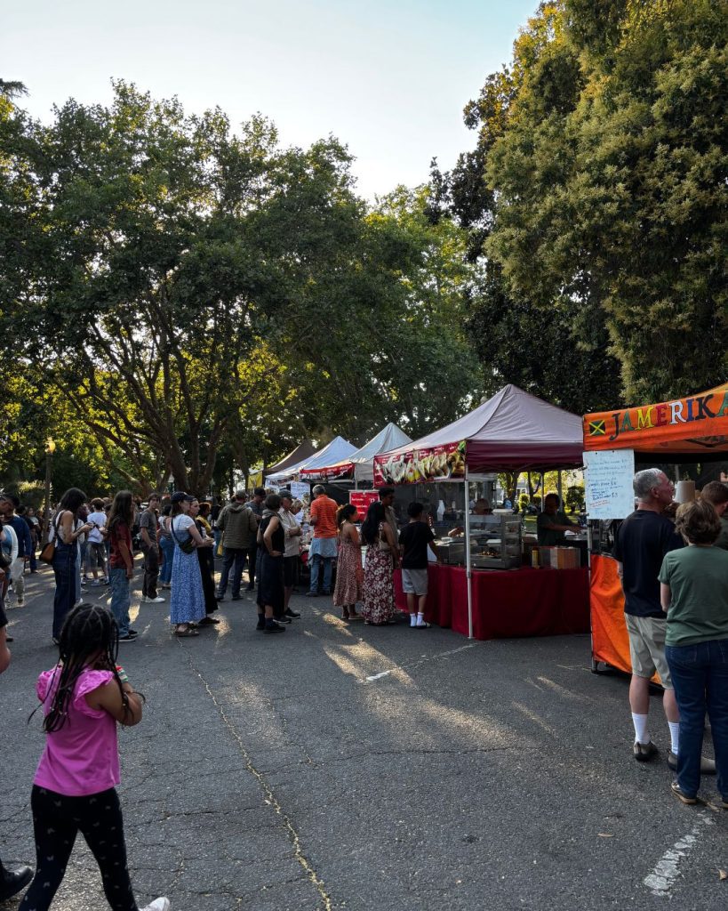 Crowds walking between food stalls at the Tuesday night farmers market in Sonoma