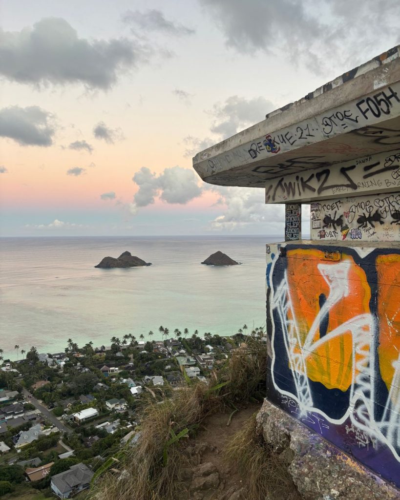 Graffiti-covered pillbox ruin on the Lanikai Pillbox trail overlooking the Mokulua islands at dusk