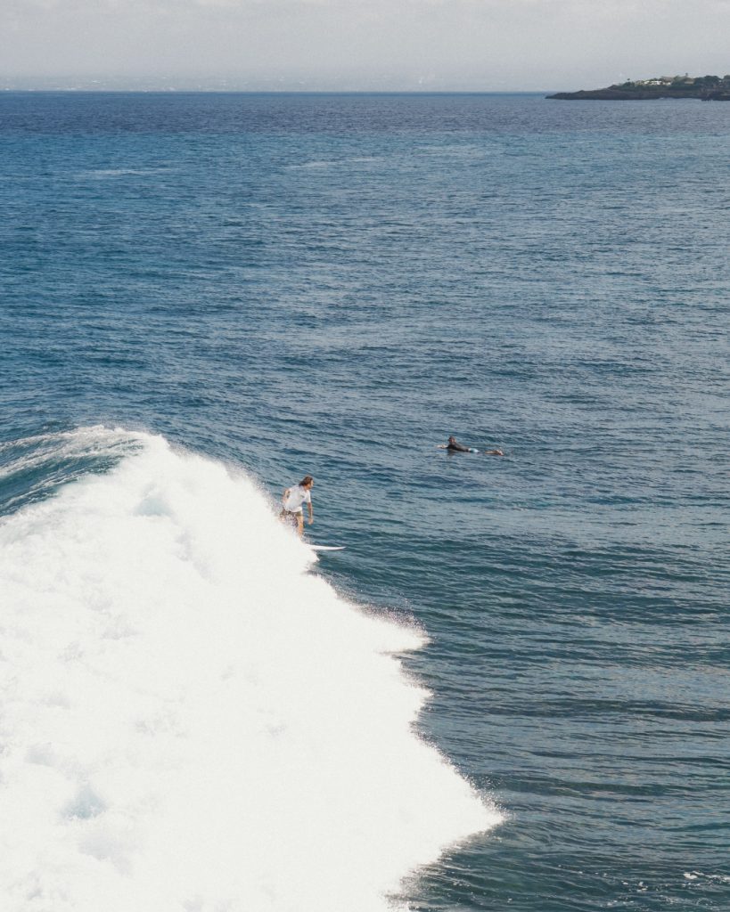 Surfer riding a wave off the coast of Nusa Lembongan