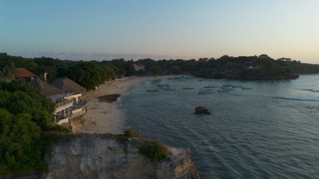 Aerial drone view of a quiet bay and beach on Nusa Lembongan at sunset