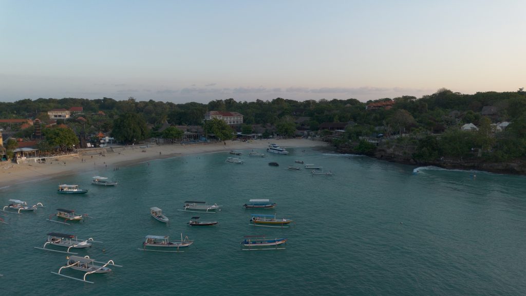 Traditional boats anchored in the calm turquoise water of Mushroom Bay Beach, Nusa Lembongan