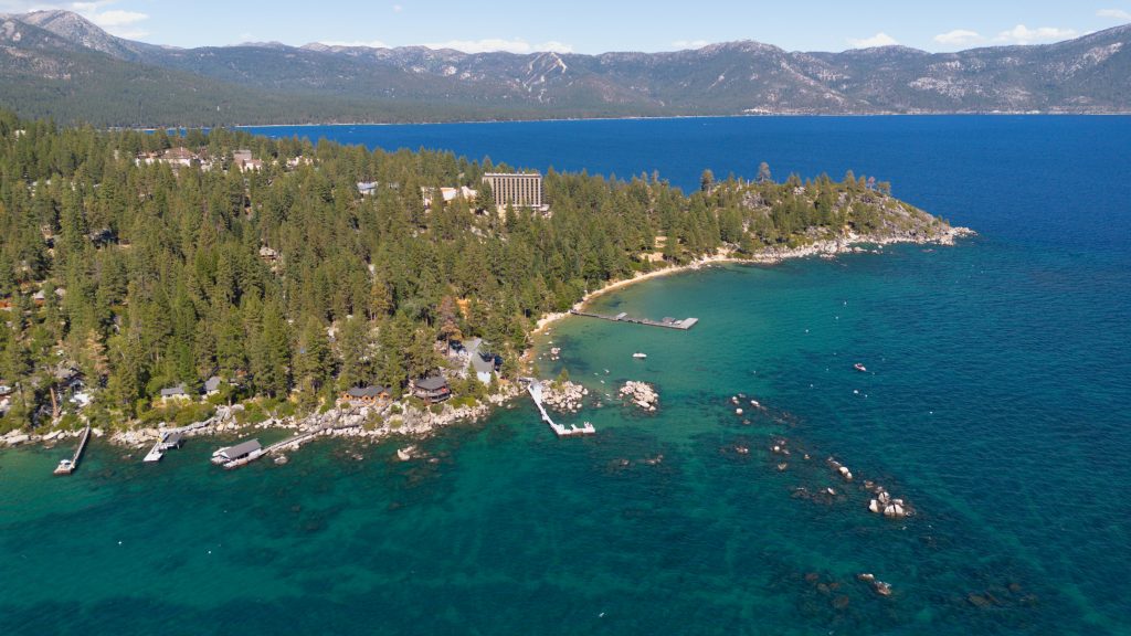 Aerial view of the turquoise shoreline and pine forest of Lake Tahoe