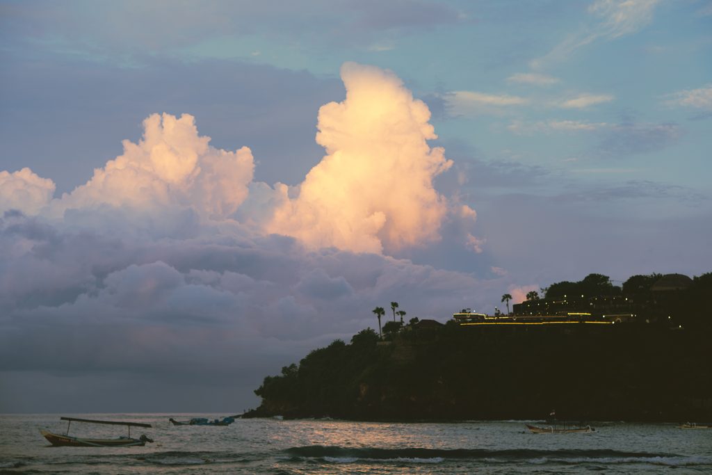 Towering clouds glowing pink at dusk over Jemeluk Bay, seen from Joli Best View Cafe in Amed