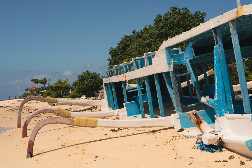 Traditional Balinese outrigger boats resting on the sand at LOA Beach, Nusa Lembongan