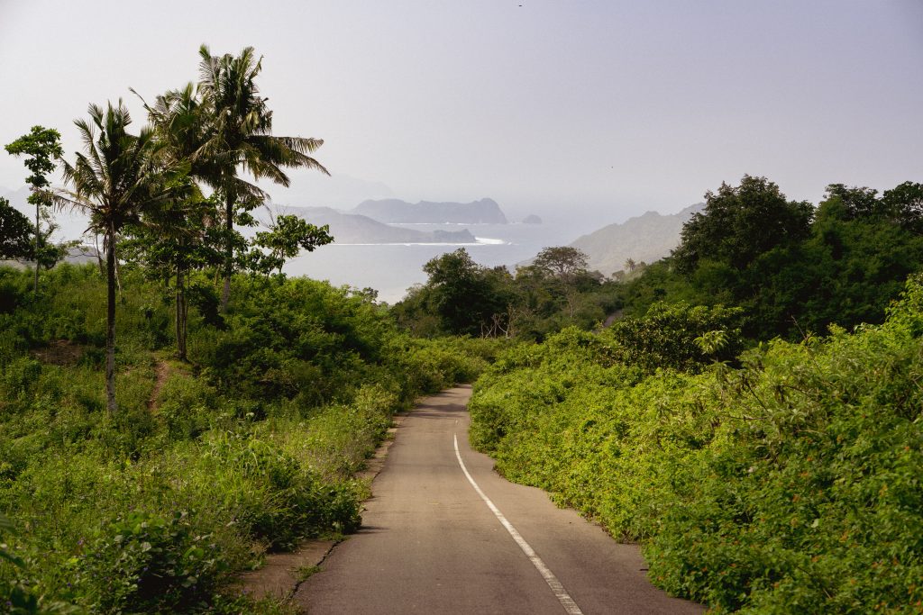 Empty narrow road winding down through jungle towards the coast on the Sekotong peninsula