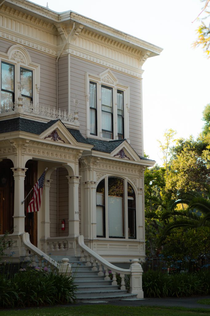A Victorian house with a covered porch and an American flag in a Napa Valley town