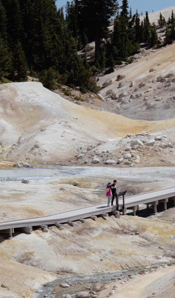 A boardwalk crossing the pale sulphur-stained ground of Bumpass Hell in Lassen Volcanic National Park