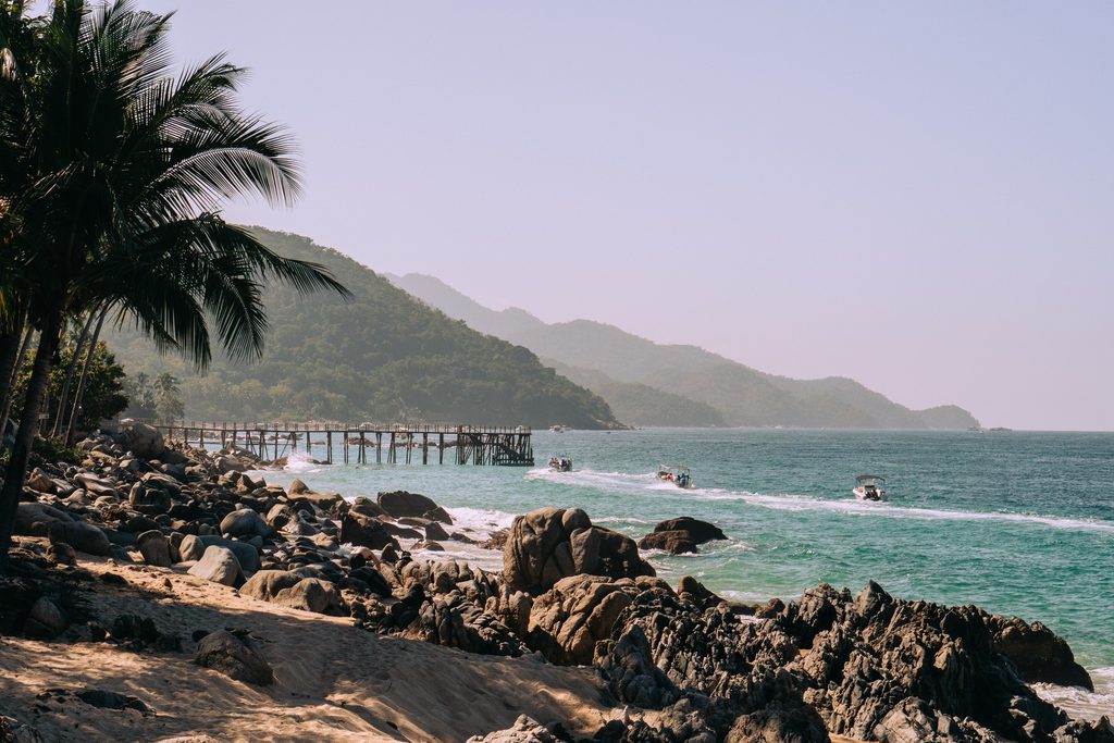 Rocky shoreline and wooden pier at Boca de Tomatlan, where the pangas leave for Yelapa