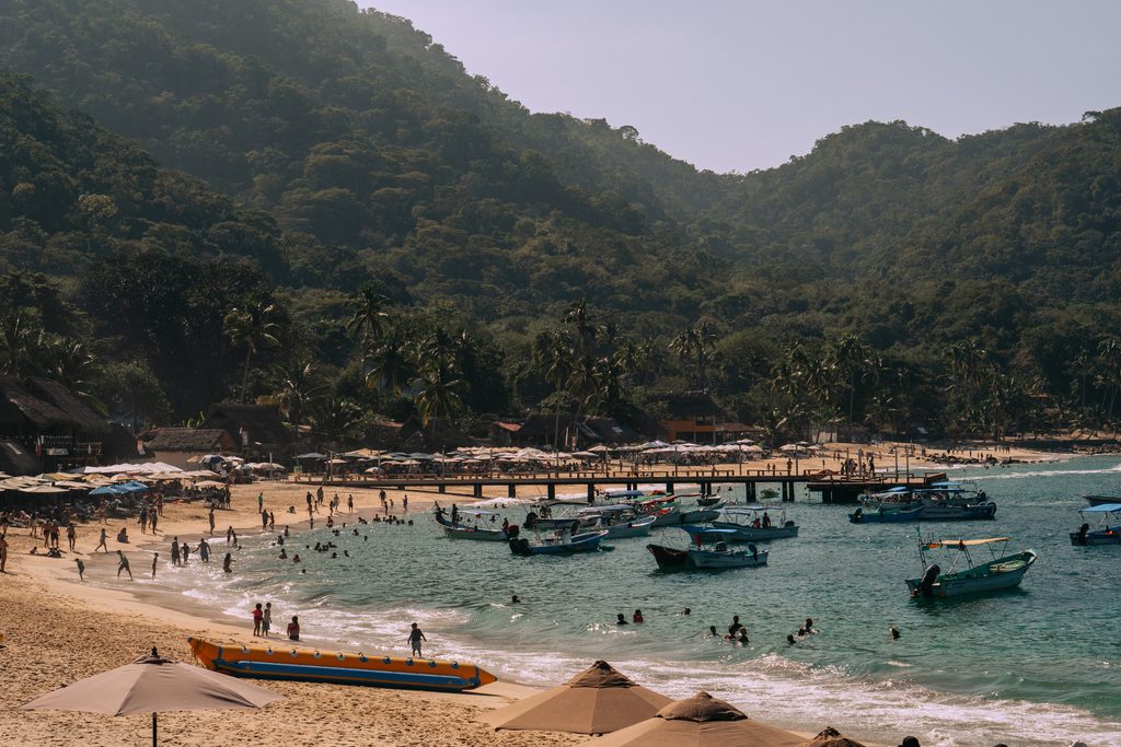 Playa Las Animas at the end of the Boca de Tomatlan hike, crowded with pangas, sun umbrellas and swimmers