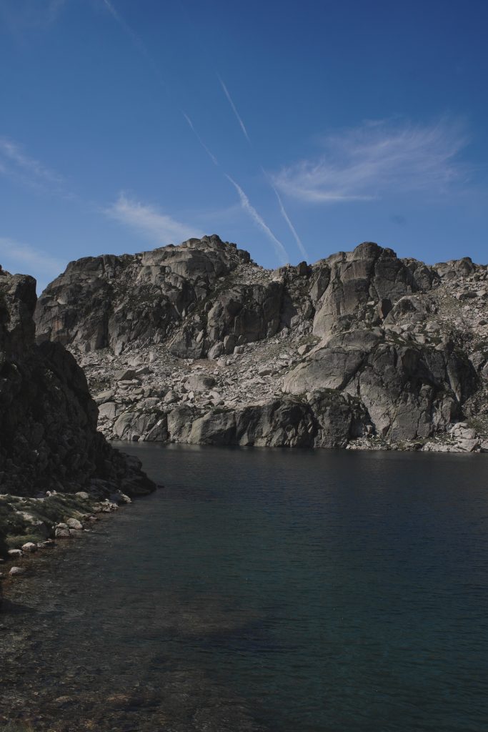 Lac d'altitude aux eaux sombres entouré de parois rocheuses escarpées dans le massif du Marcadau.