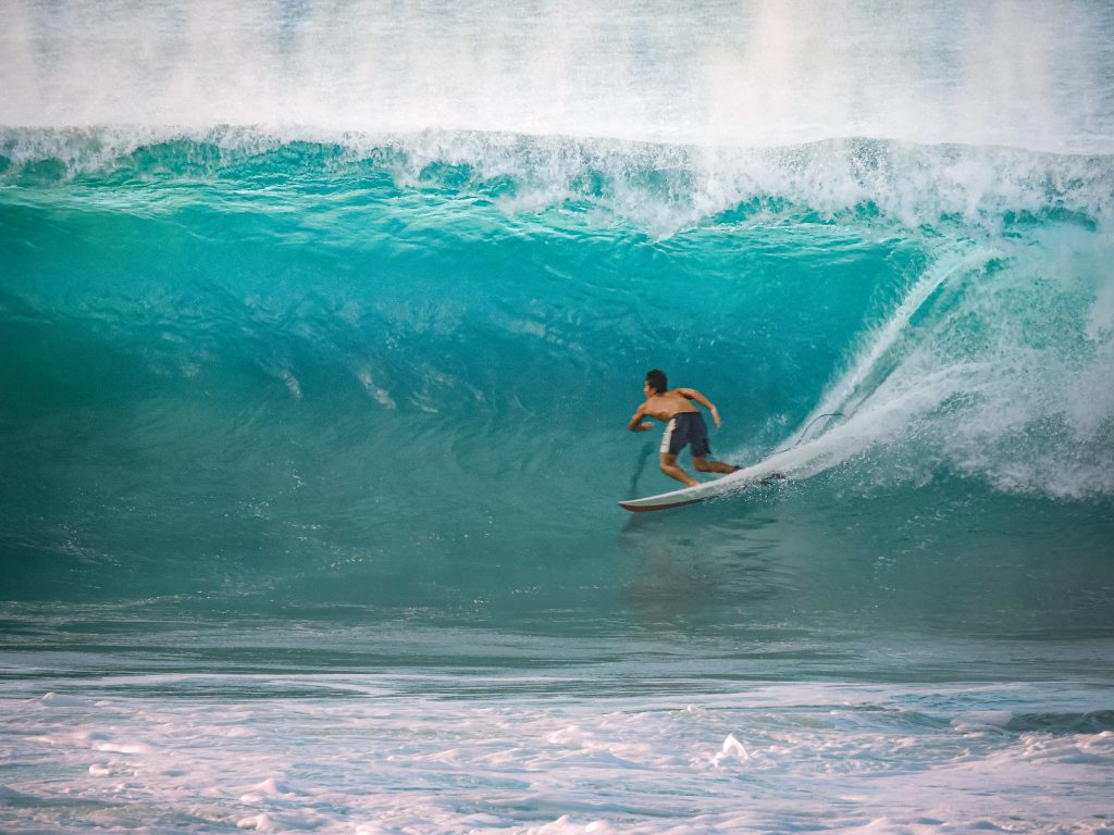 Surfer riding a large barreling wave at Banzai Pipeline on Oahu's North Shore