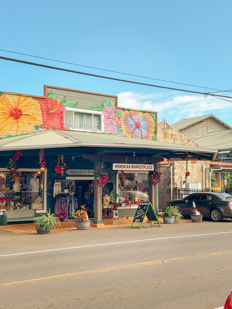 Colorful storefronts along the main street of Honokaa, with paper parasols hanging under the awning