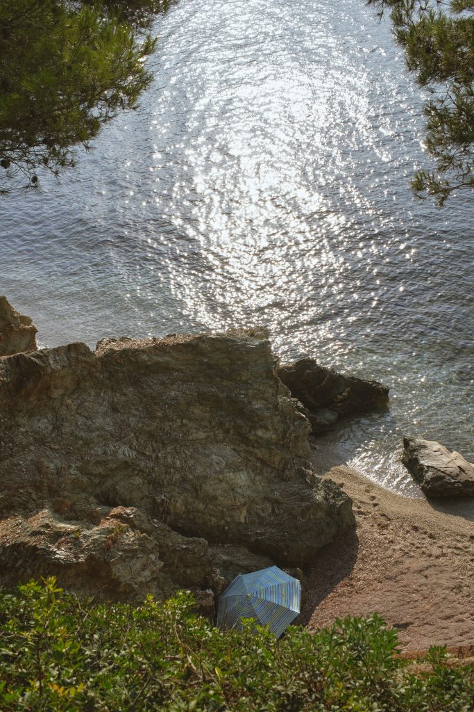 Sunlight scattering on clear water above dark rocks on the Presqu'ile de Giens